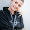 Junge Frau mit schwarzem Pullover mit Aufdruck und Strass-Elementen