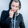 Junge Frau mit schwarzem Pullover mit Aufdruck und Strass-Elementen
