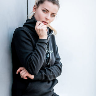 Junge Frau mit schwarzem Pullover mit Aufdruck und Strass-Elementen