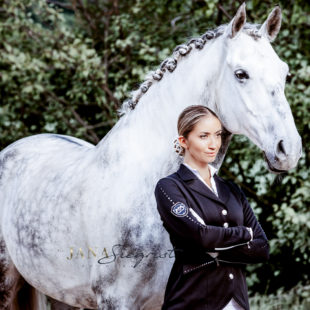 Schöne Frau mit Pferd und Turnierjacket in Schwarz mit Stass Elementen