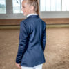 Junge Frau mit Pferd und Reitjacket in Navyblau
