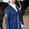 Junge Frau mit Pferd und Reitjacket in Navyblau