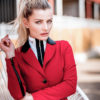 Schöne Frau mit Schimmel Pferd in einem auffälligen Reitblazer