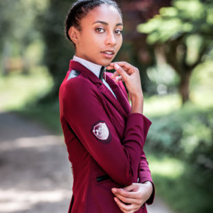 Schöne Frau mit auffälligem Turnierjackett in Berry