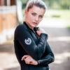 Junge Frau mit elegantem Longsleeve in Schwarz für den Reitsport