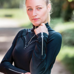Junge Frau mit elegantem Longsleeve in Schwarz für den Reitsport