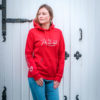 Junge Dame präsentiert einen Hoodiein Rot für den Reitsport, Detailansicht