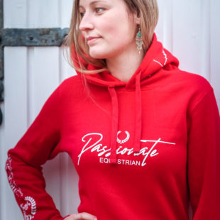 Junge Dame präsentiert einen Hoodiein Rot für den Reitsport, Detailansicht