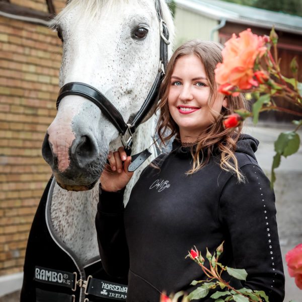 Junge Frau mit schwarzem Pullover mit Strass an Kapuze und Ärmeln