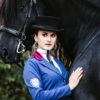 Sinnliche Frau mit schwarzem Pferd und besonderem Reitjacket