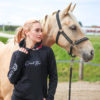 Junge Frau präsentiert einen Hoodie für den Reitsport, Detailansicht